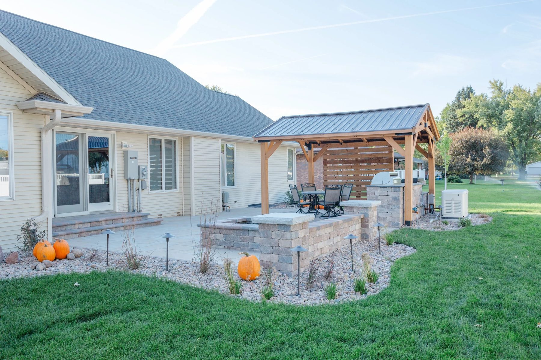Completed outdoor living space with patio, pergola, and fire pit